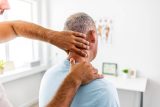 Chiropractor using his hands to adjust a patient's spine and neck in a medical office.